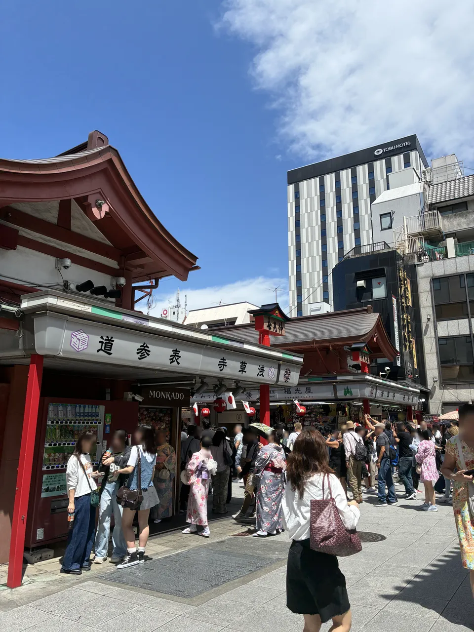Rotated view of the Kaminarimon Gate area in Asakusa crowded with festival visitors including people wearing kimono, with the 浅草参道 (Asakusa Sando) sign and red