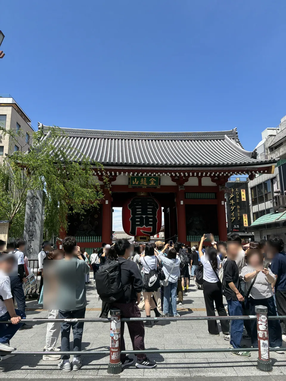 Rotated view of a large crowd in front of the Kaminarimon Gate (Thunder Gate) at Senso-ji in Asakusa, the red gate with its large black-and-red 雷門 lantern visib