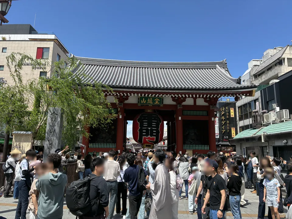 The Kaminarimon Gate at Senso-ji in Asakusa viewed from across the street with a dense crowd of festival visitors, the red gate with 金龍山 sign and 大提灯 (large lan