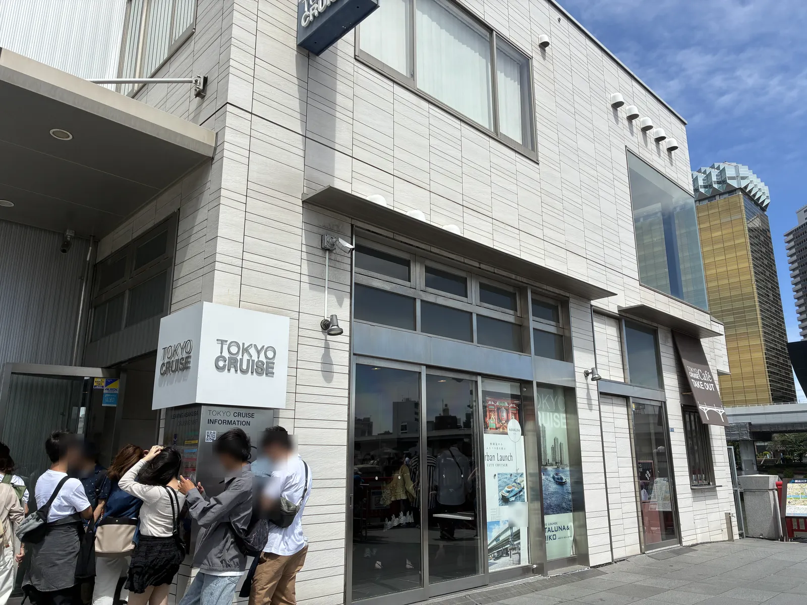 The Tokyo Cruise building at Asakusa Pier: a light-coloured two-storey building with the TOKYO CRUISE sign over the entrance and an information desk beside it.