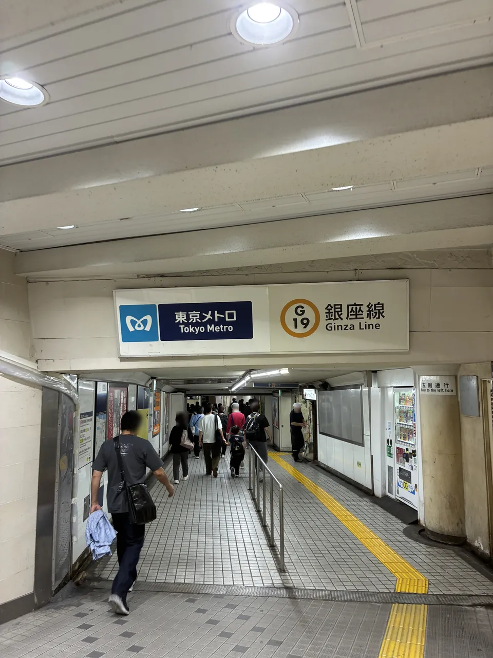 Underground passage at Asakusa with an overhead Tokyo Metro sign reading G19 Ginza Line and passengers walking toward the ticket gates