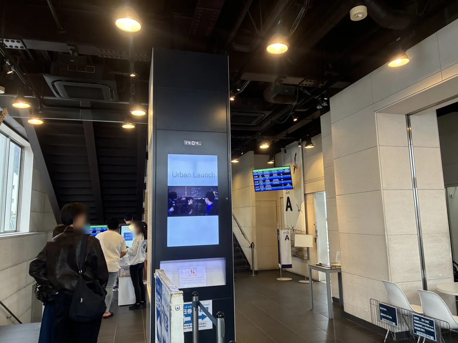 Inside the Asakusa Pier ticket hall, with the departures screen on the wall at the back and the timetable board near the entrance.